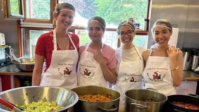 Volunteers from Nourish Camden posing with food they have prepared for people experiencing homelessness